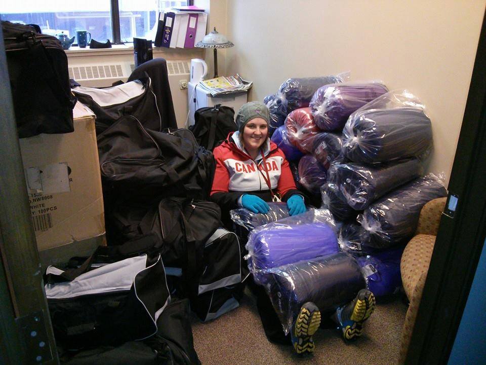 Celia, from AIDS Committee Durham Region, is surrounded by sleeping bags as she works on the winter survival project at 22 King St., 2015.